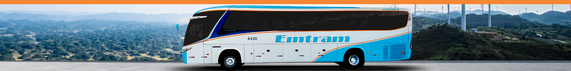 Foto de um ônibus adesivado da Emtram em uma estrada com uma vista de montanhas