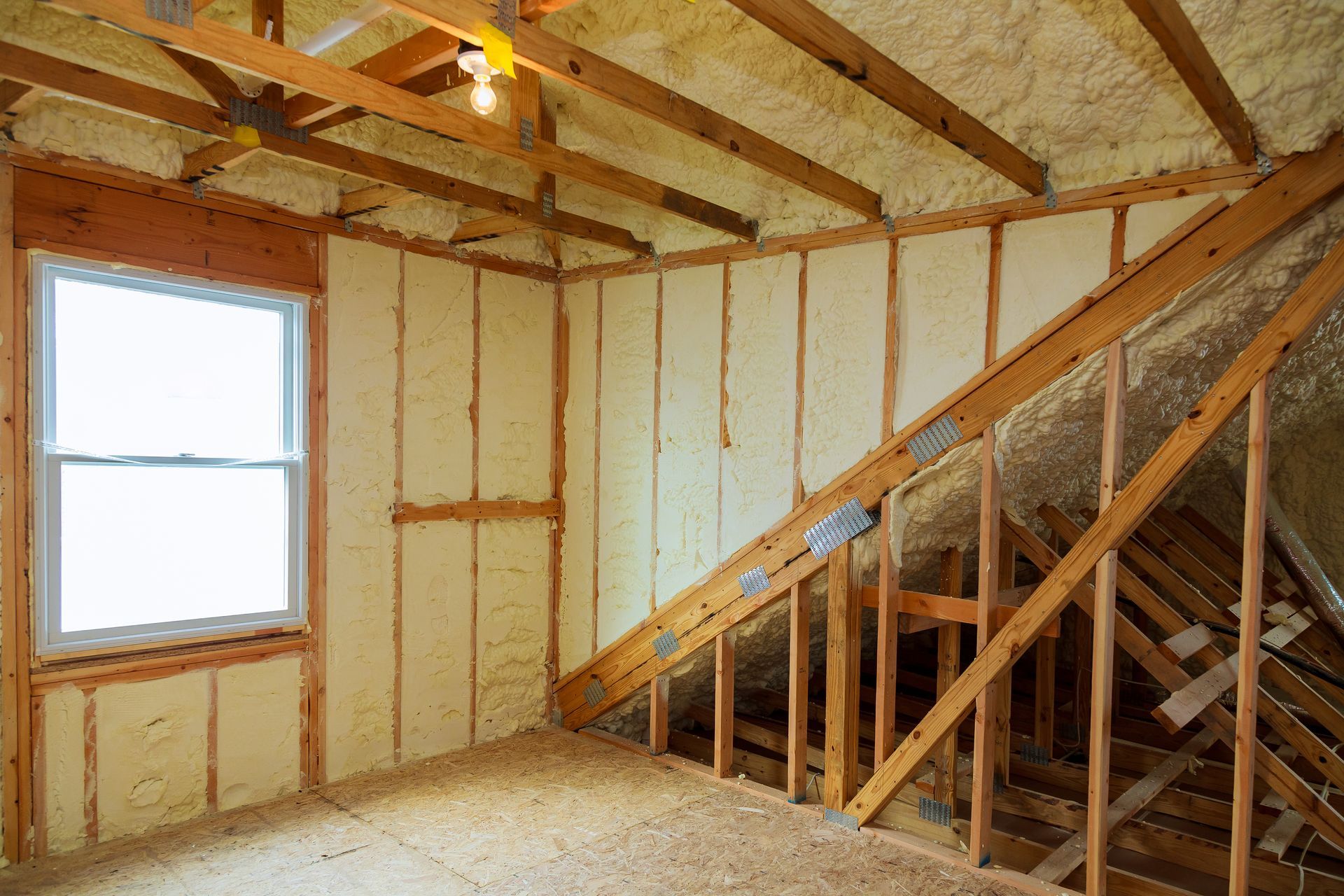 A room with wooden beams and foam insulation on the walls.