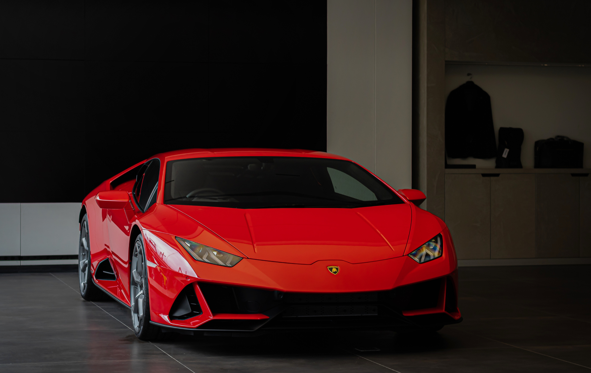 A red lamborghini huracan is parked in a showroom.