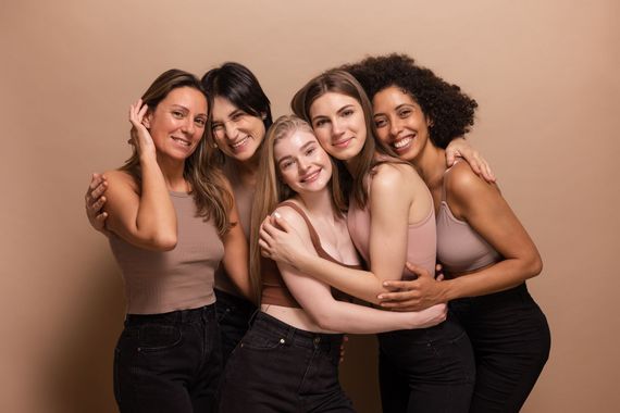 A group of women are hugging each other and posing for a picture.