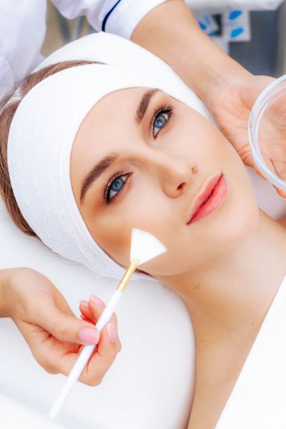 A woman is getting a facial treatment at a beauty salon.