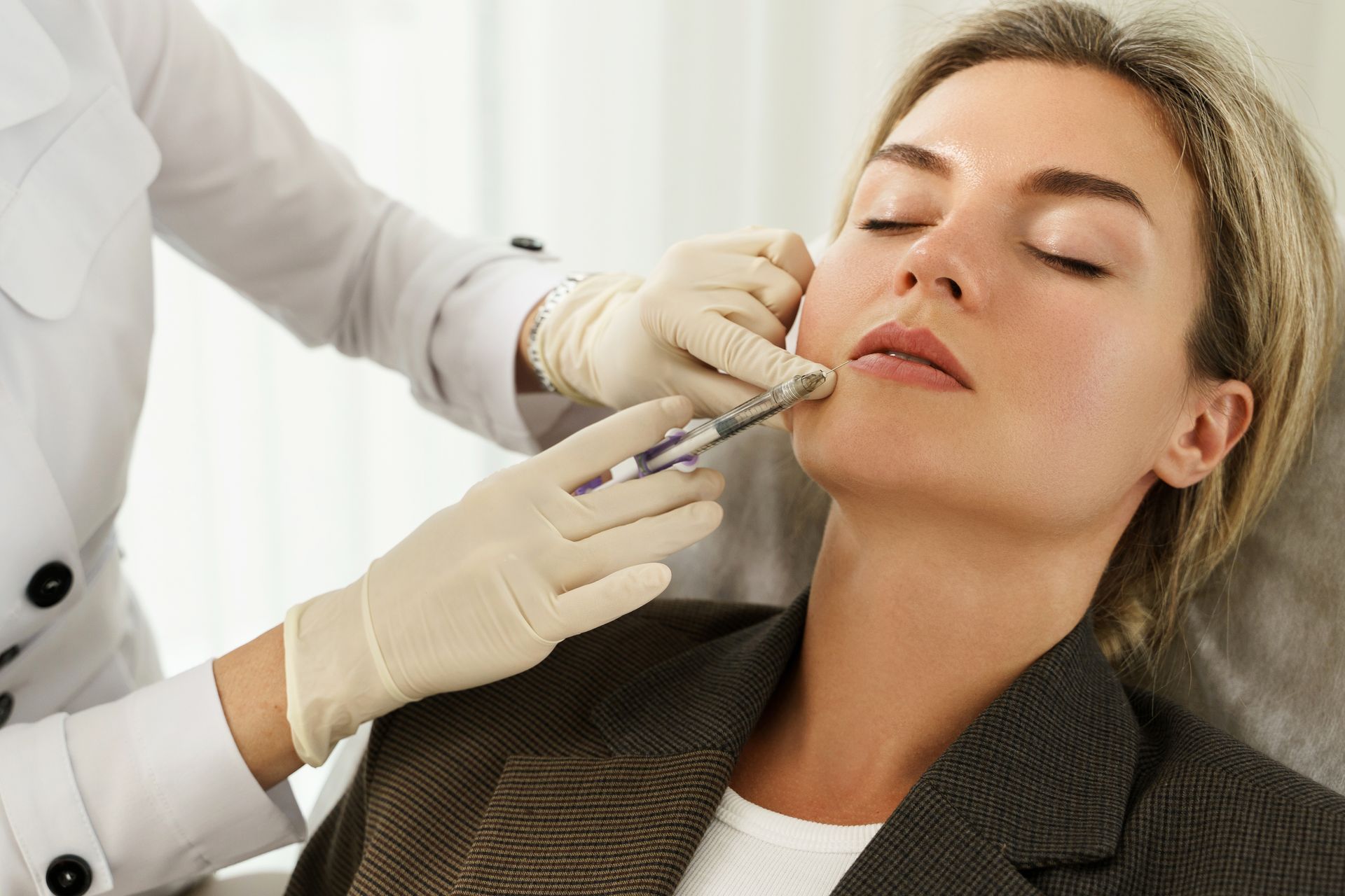 A woman is getting a botox injection in her face.