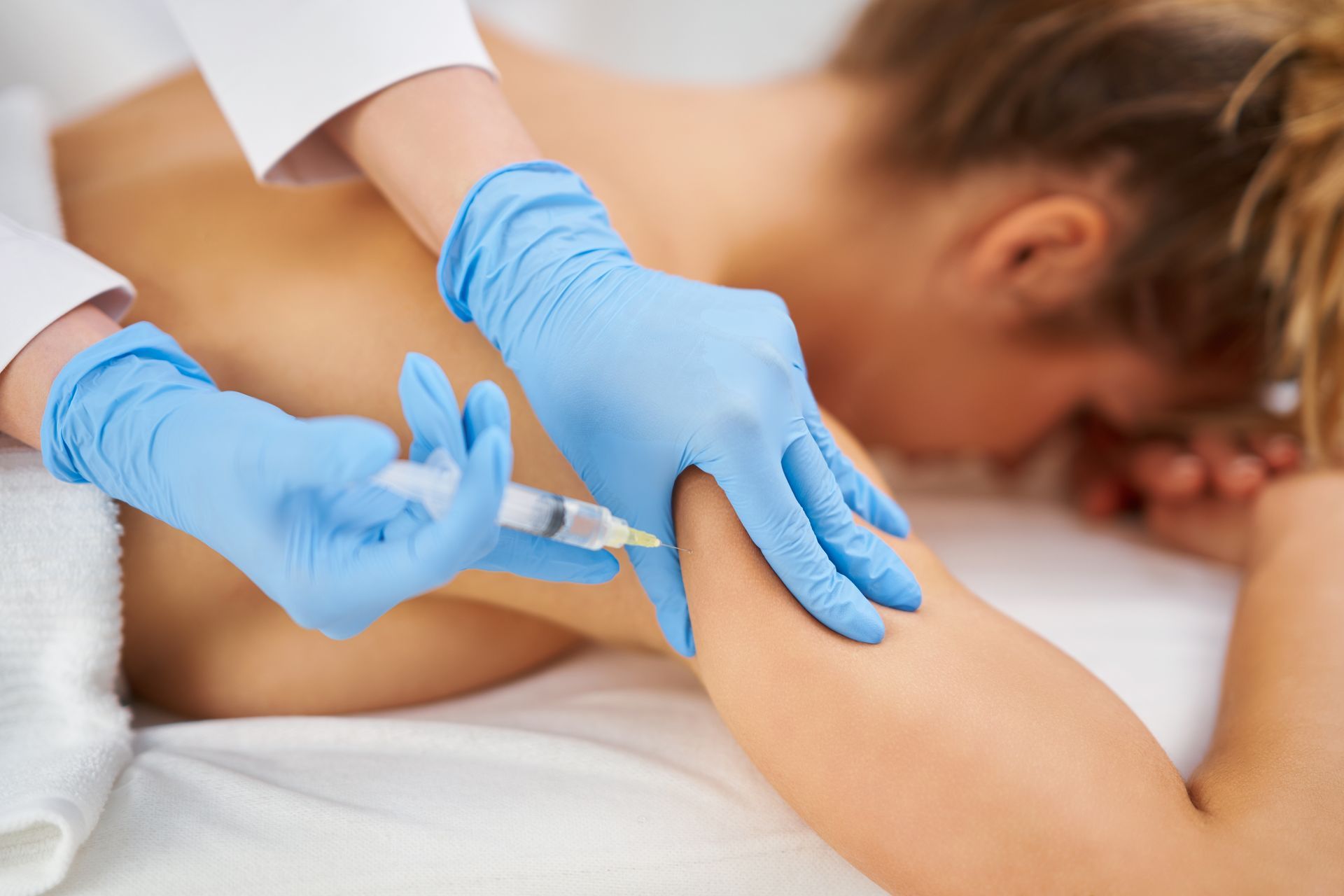 a woman is getting an injection in her arm