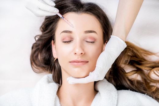 a woman is getting a botox injection in her forehead
