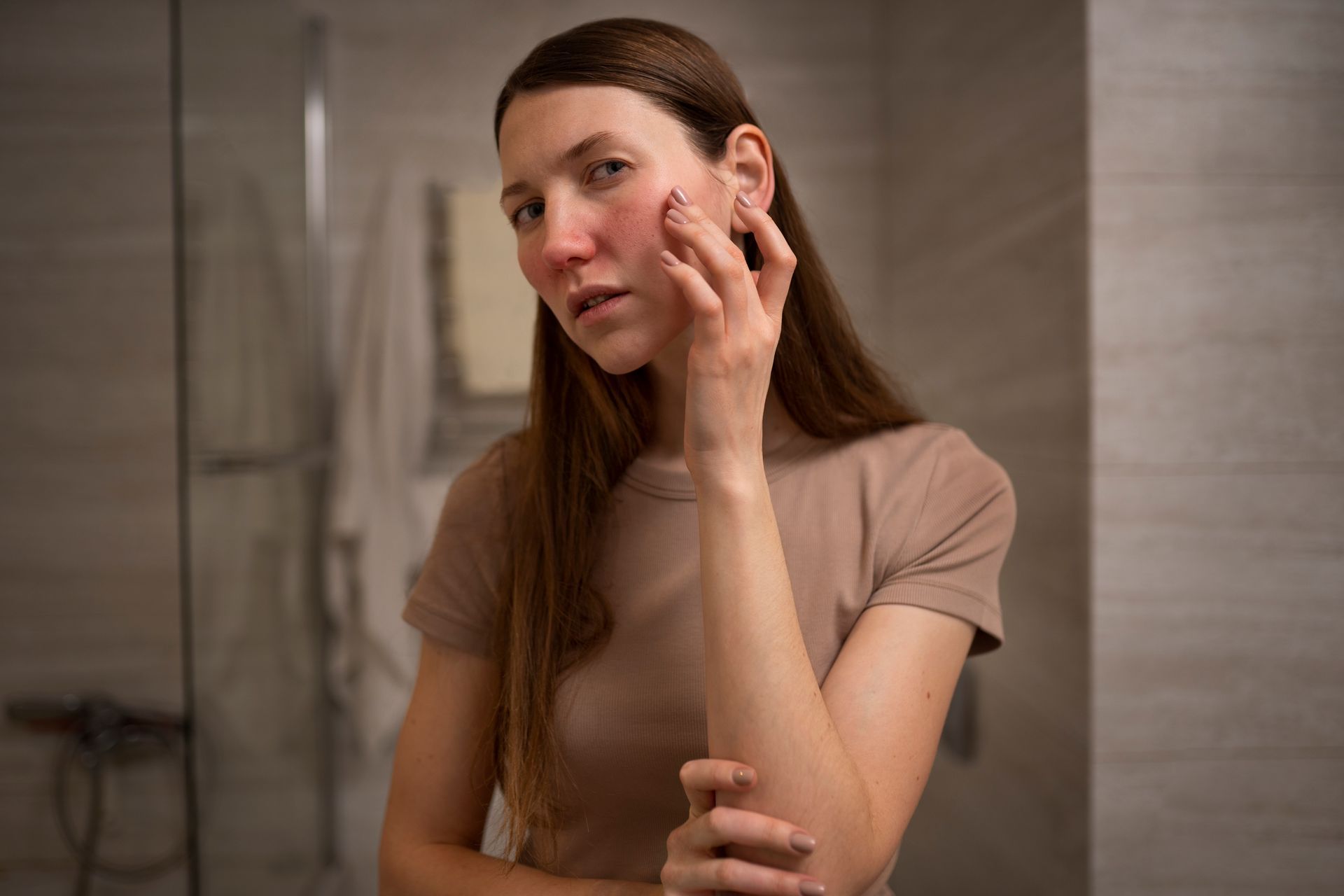 a woman touches her face in front of a mirror