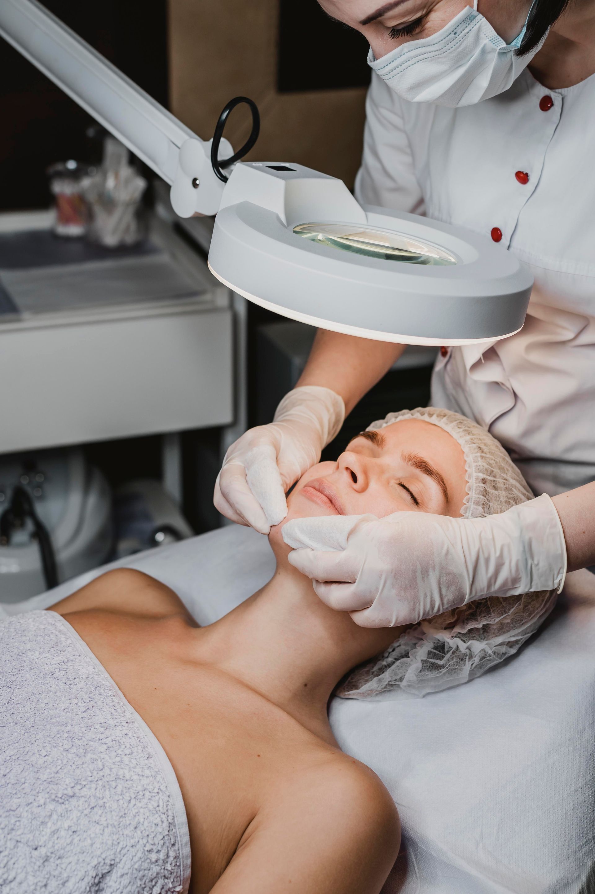 A woman is getting a facial treatment at a beauty salon.