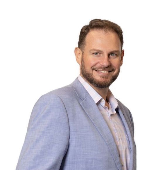 Duane Dormehl from DormFin in light blue blazer smiles, looking to the side. White background.