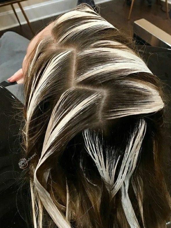 A close up of a woman 's hair with white highlights.