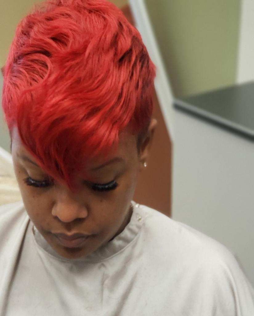 A woman with red hair is wearing a white shirt.