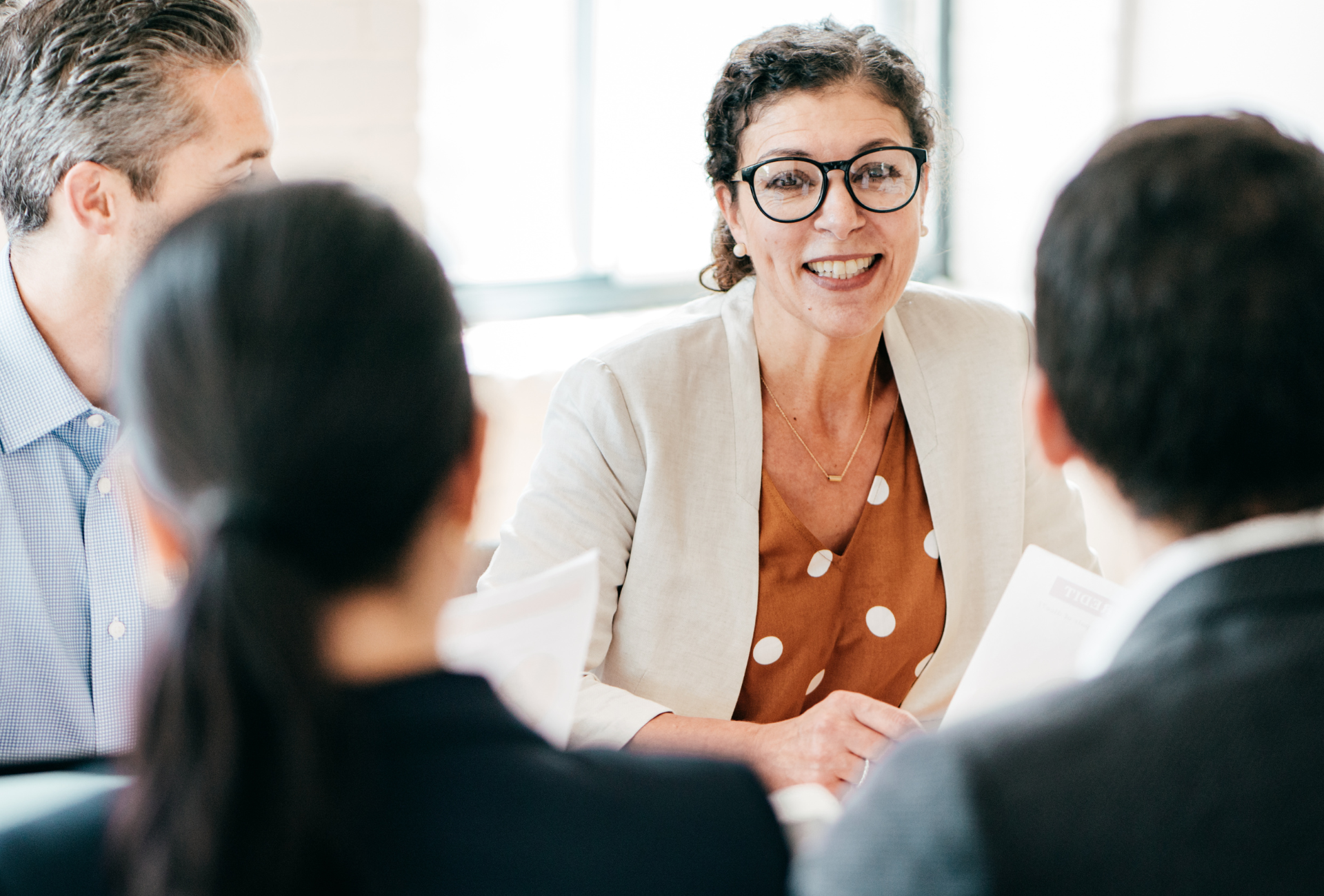 A group of people are sitting around a table having a meeting.