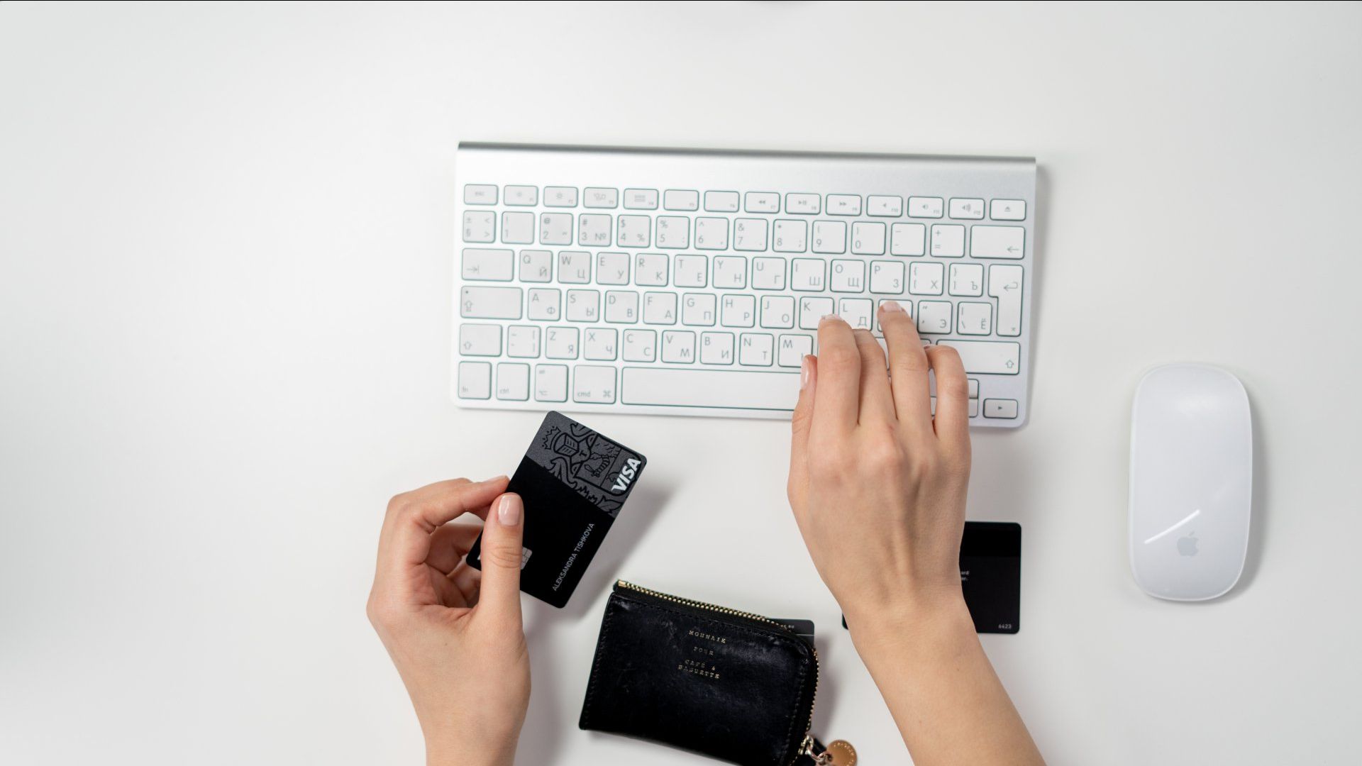 Hand holding a credit card and keyboard