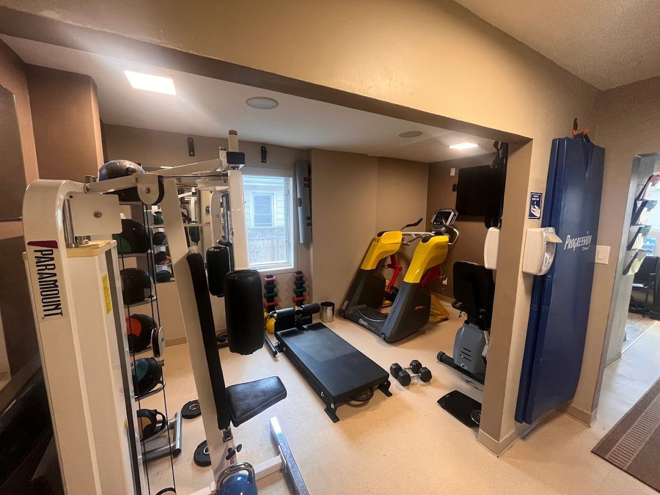 A gym with a lot of equipment and a window.