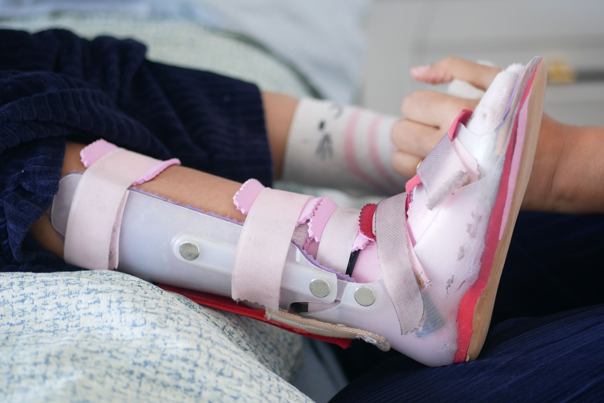 A child with a brace on their leg is laying on a bed.