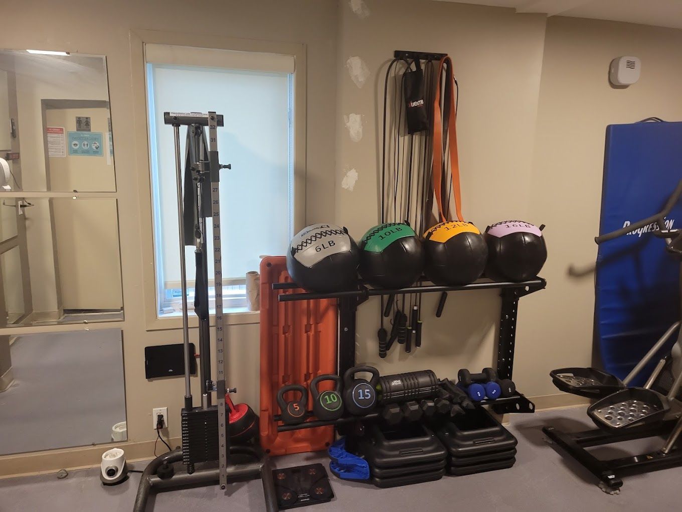 A gym with a lot of exercise equipment and a mirror.