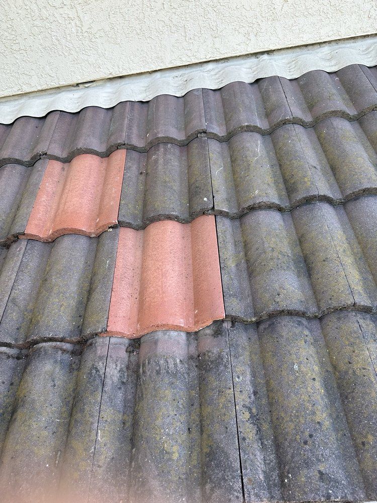 A close up of a roof with a red tile missing.