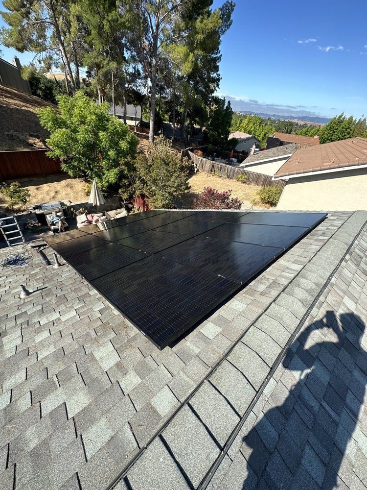 A person is taking a picture of a solar panel on a roof.