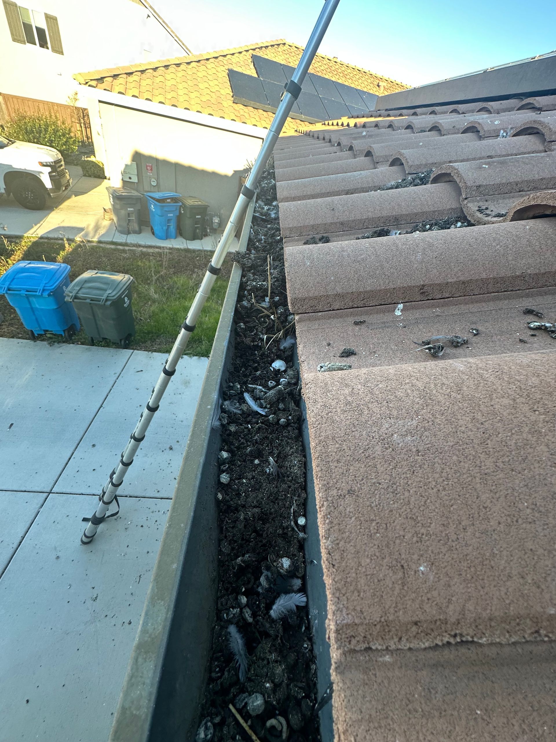 A gutter with a hose attached to it is sitting on top of a roof.
