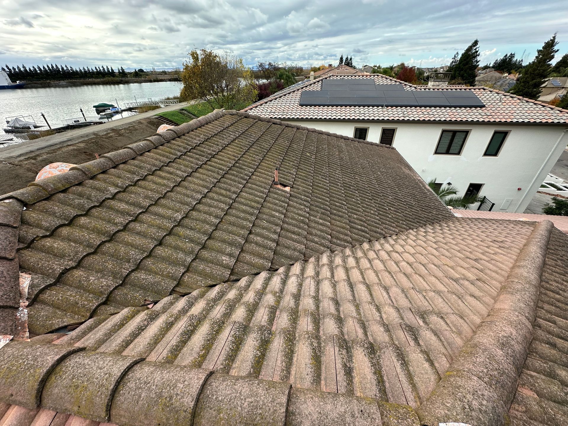 A house with a tiled roof and solar panels on the roof.