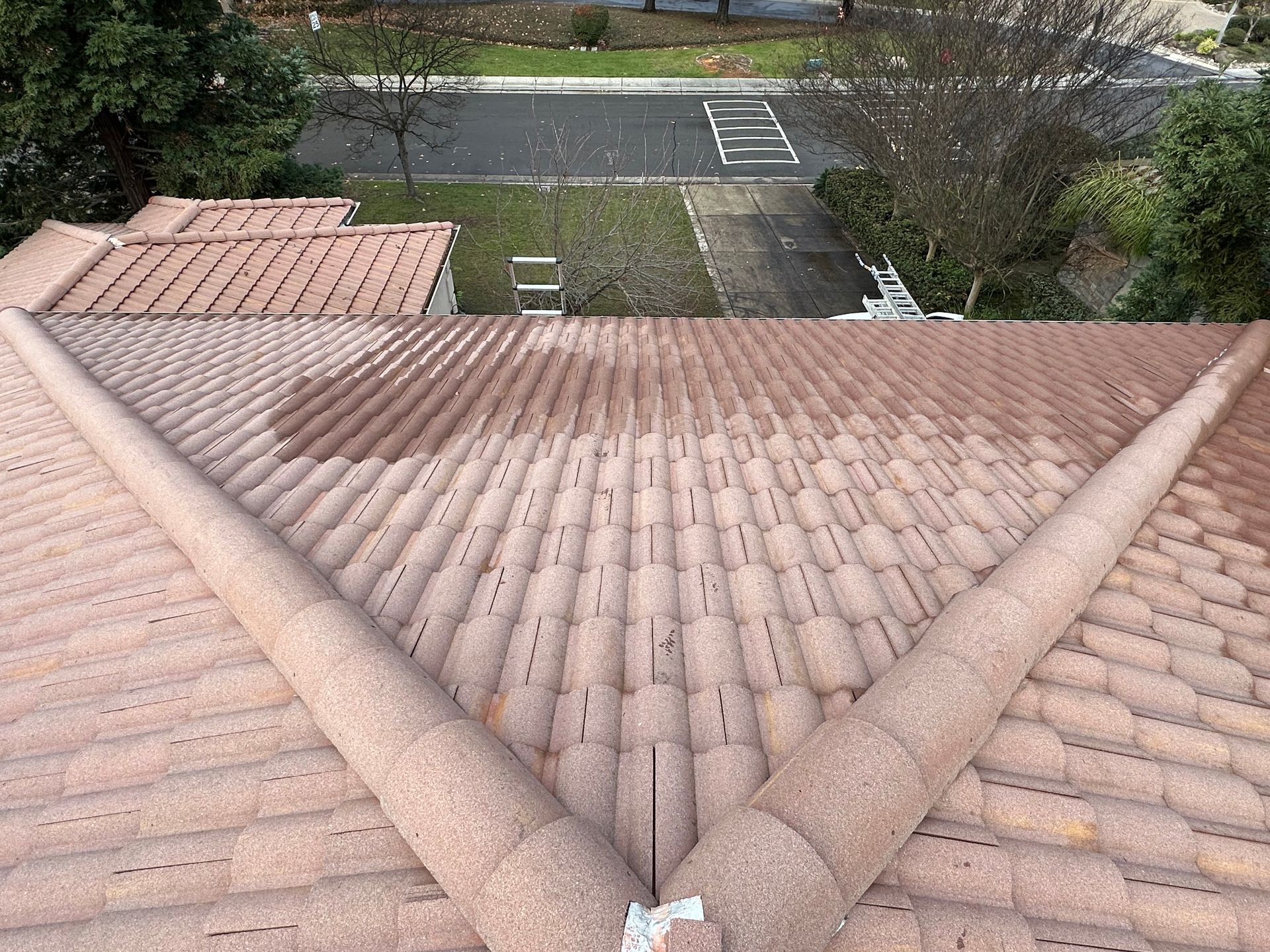 An aerial view of a tiled roof with a street in the background.