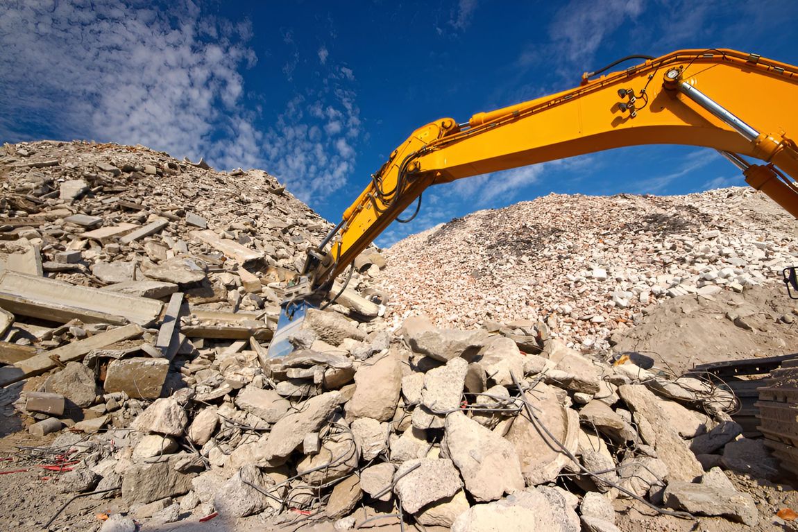A Yellow Excavator Is Working On A Pile Of Rocks — ACC Excavations & Demolition Pty Ltd In Oak Floats, NSW