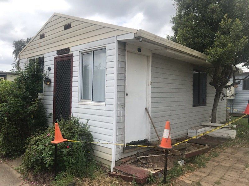 A Small White House With Orange Cones In Front Of It — ACC Excavations & Demolition Pty Ltd In Oak Floats, NSW