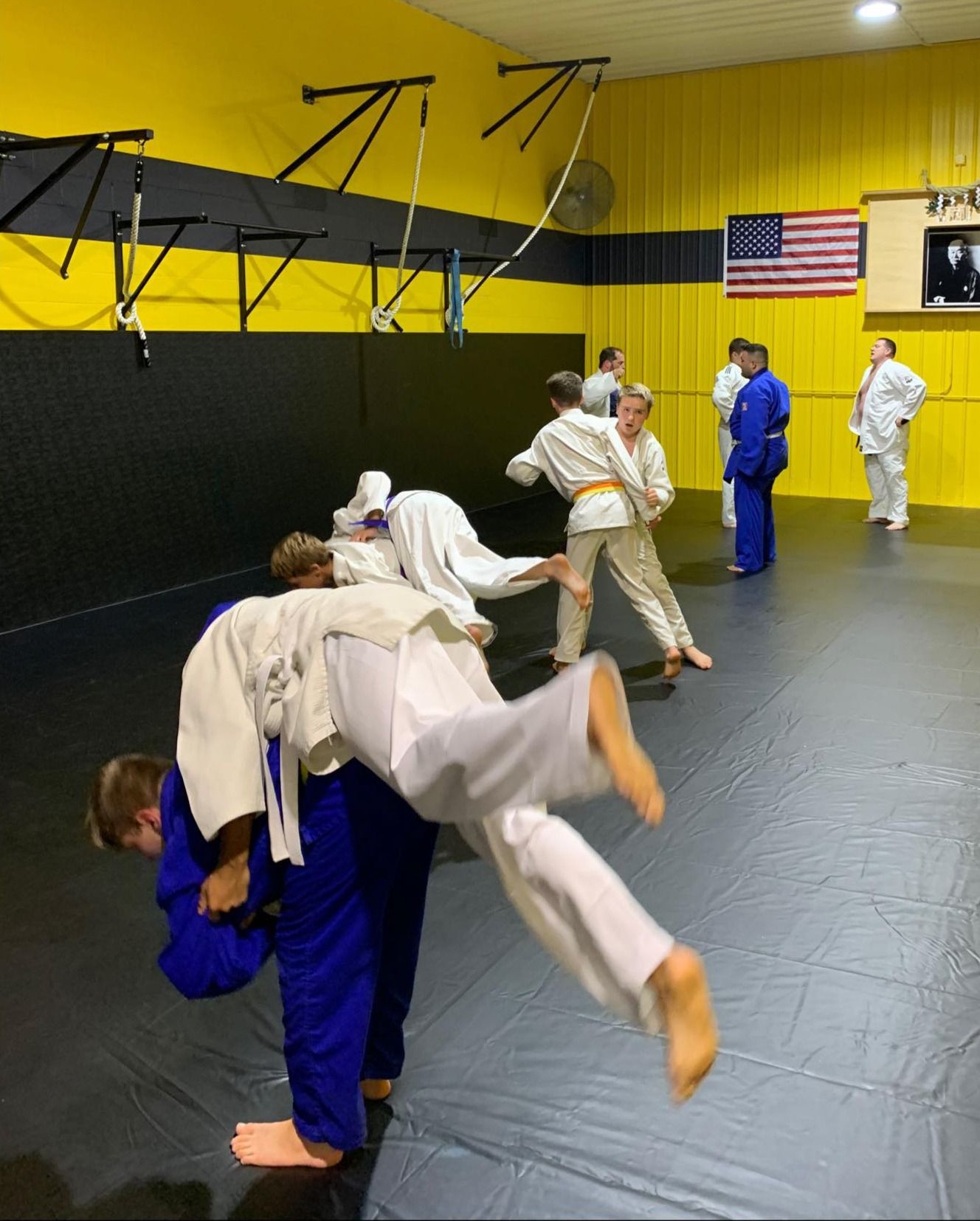 Four men in athletic gear, posing for a photo in a gym.