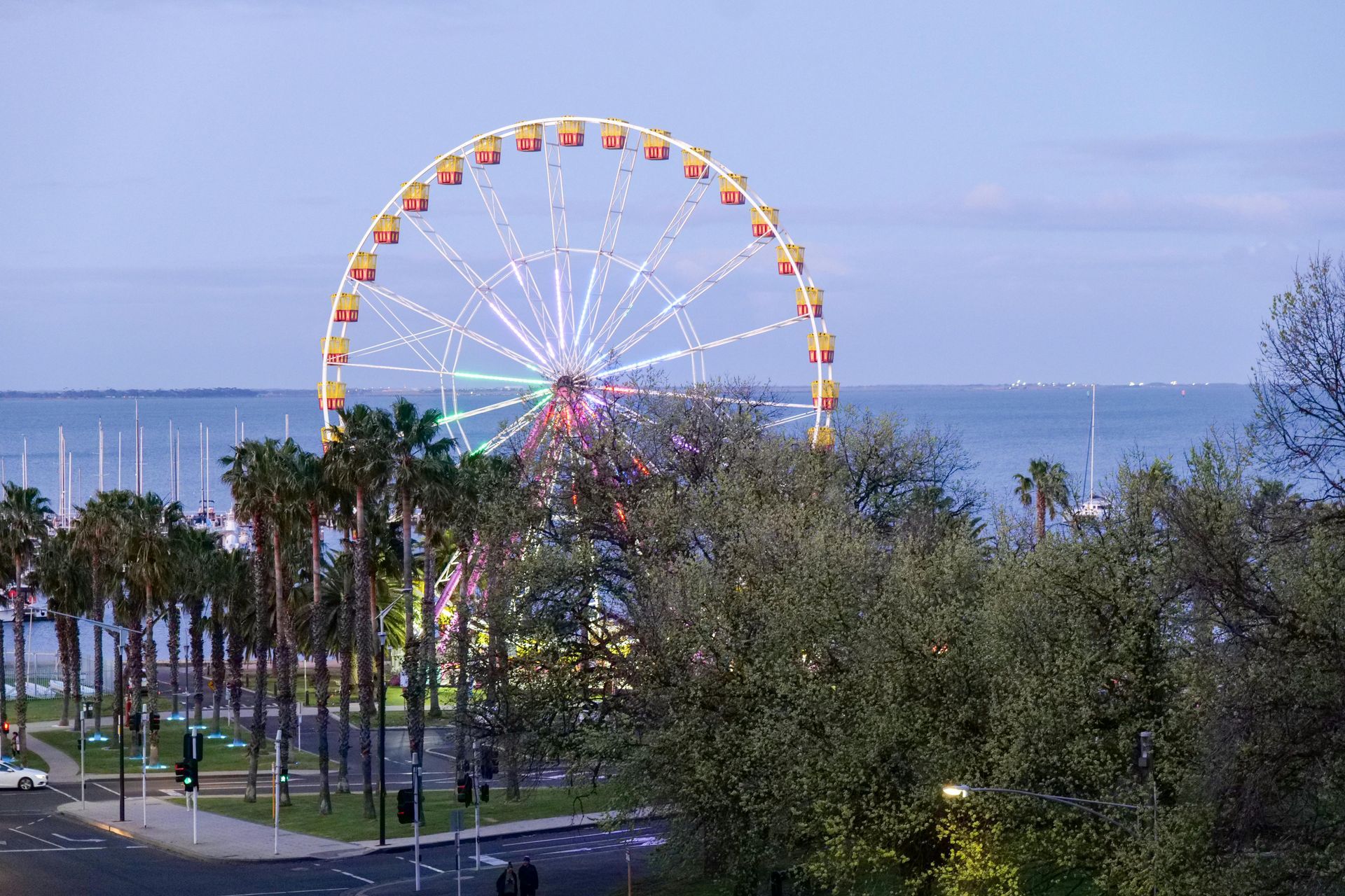 Binoculars overlooking the New York City skyline, including the Empire State Building, under a partly cloudy sky.