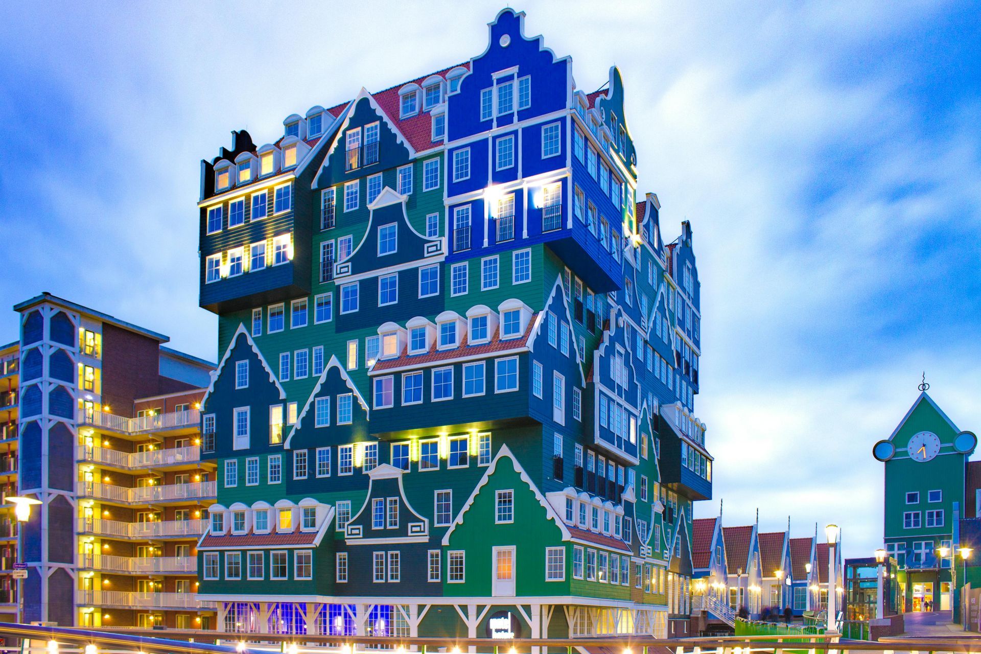 Colorful building in Zaandam, Netherlands, designed to resemble stacked traditional houses, lit up at dusk.