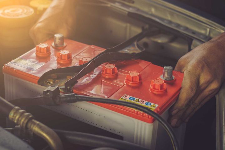 Man Holding a Red Car Battery — Car Battery Replacement in South Lismore, NSW