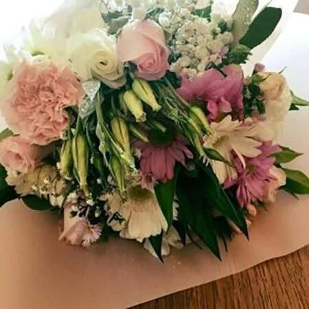 A Bouquet of Flowers is Sitting on a Wooden Table — Flower Hunt in Robina, QLD