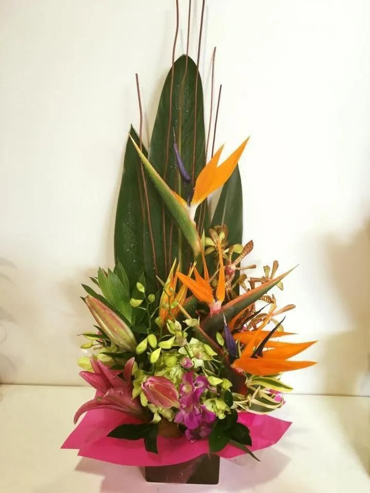 A Vase Filled With Flowers and Leaves on a Table — Flower Hunt in Robina, QLD