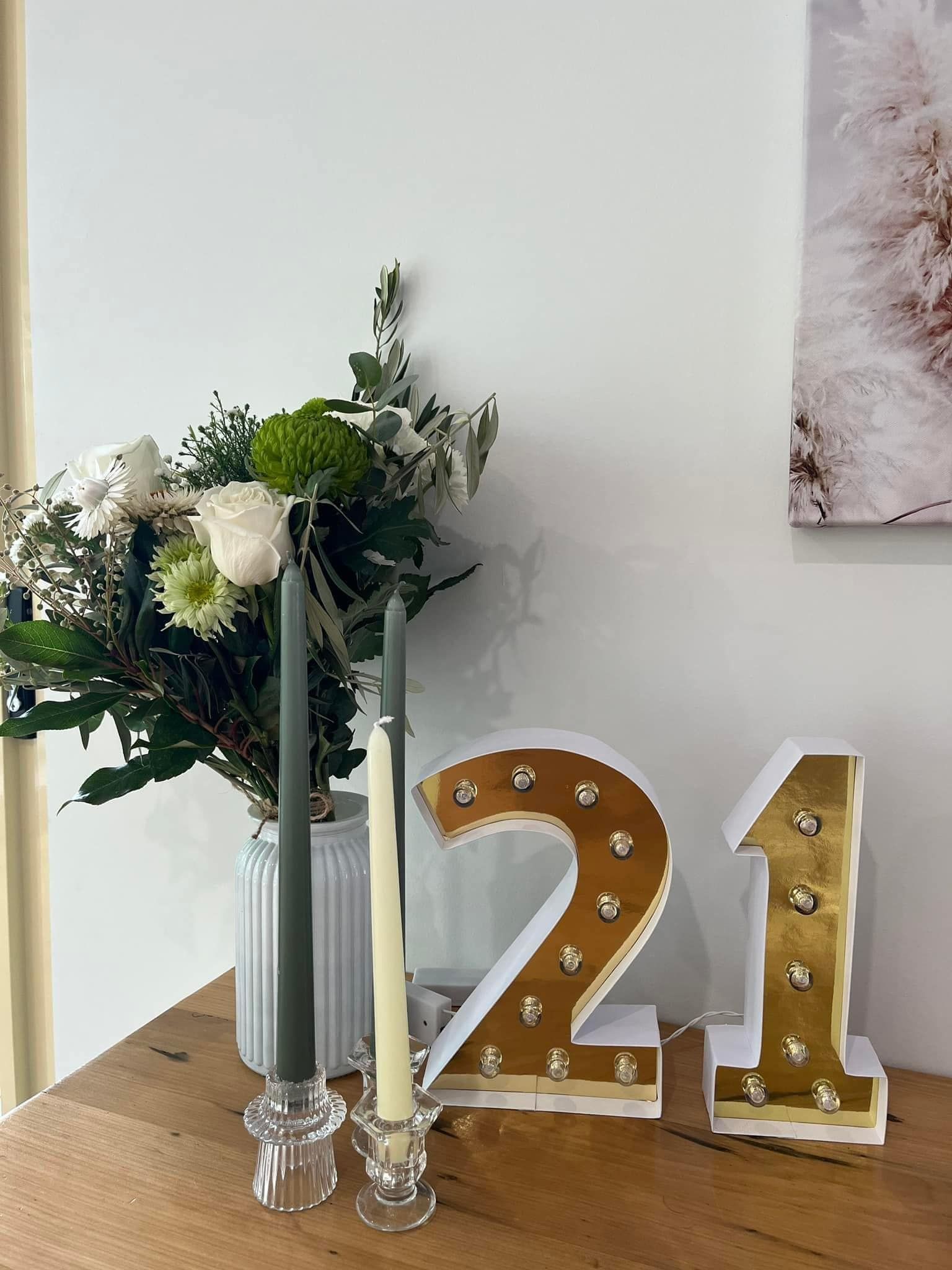 A Table With a Vase of Flowers and Candles and a Number 21 on It — Flower Hunt in Robina, QLD
