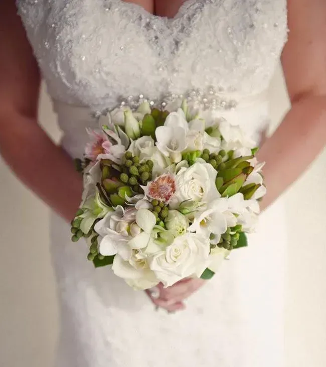 A Bride in a White Dress is Holding a Bouquet of White Flowers — Flower Hunt in Robina, QLD