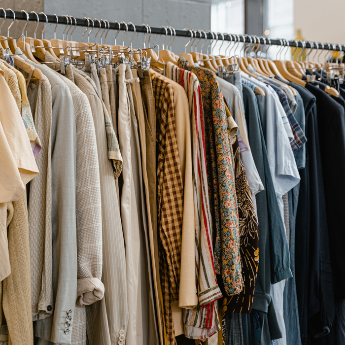 A row of clothes hanging on a rack in a store.