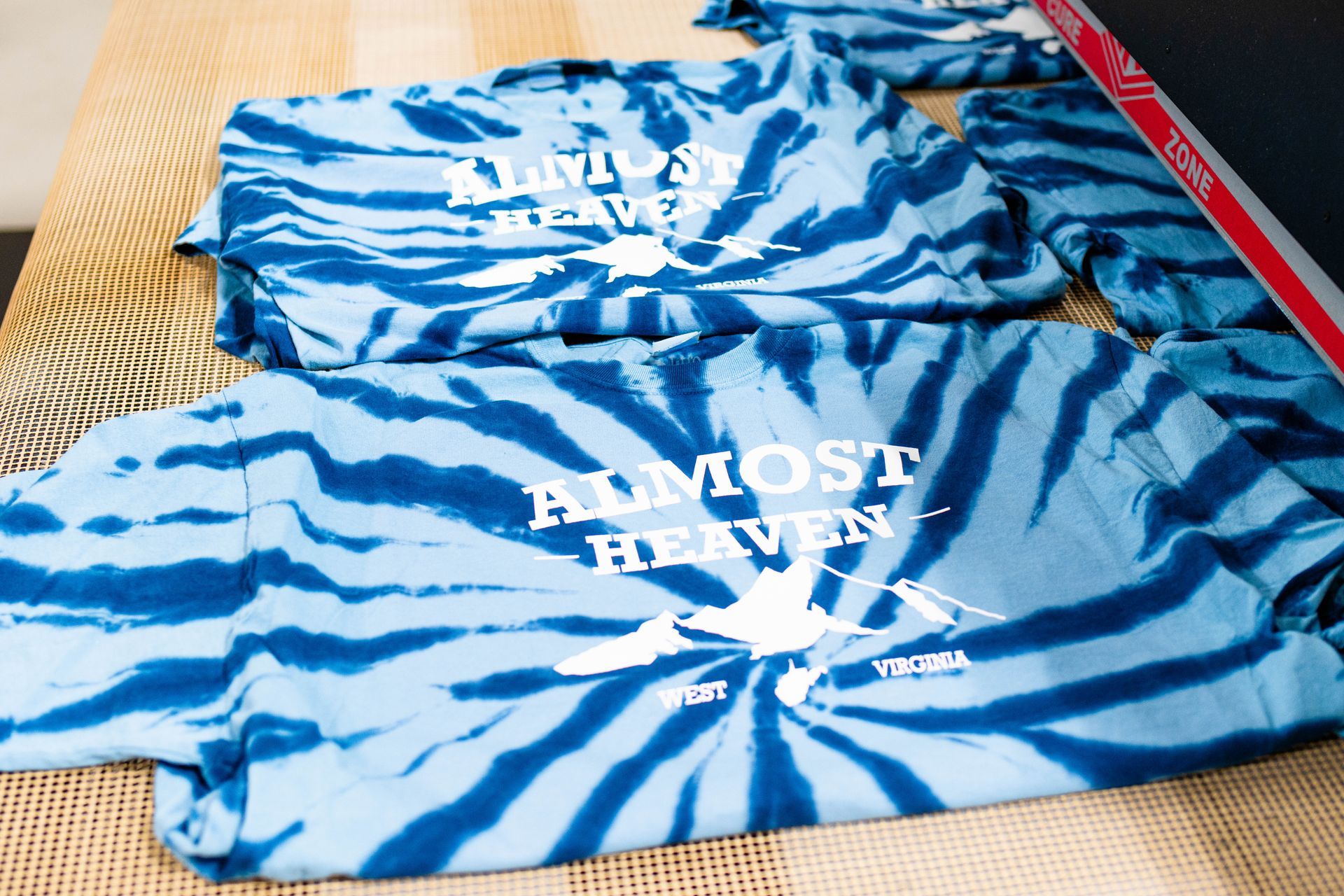 A tie dye shirt that says almost heaven on it