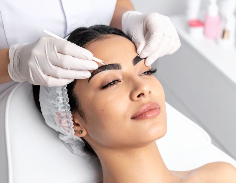 Woman receiving eyebrow microblading treatment.