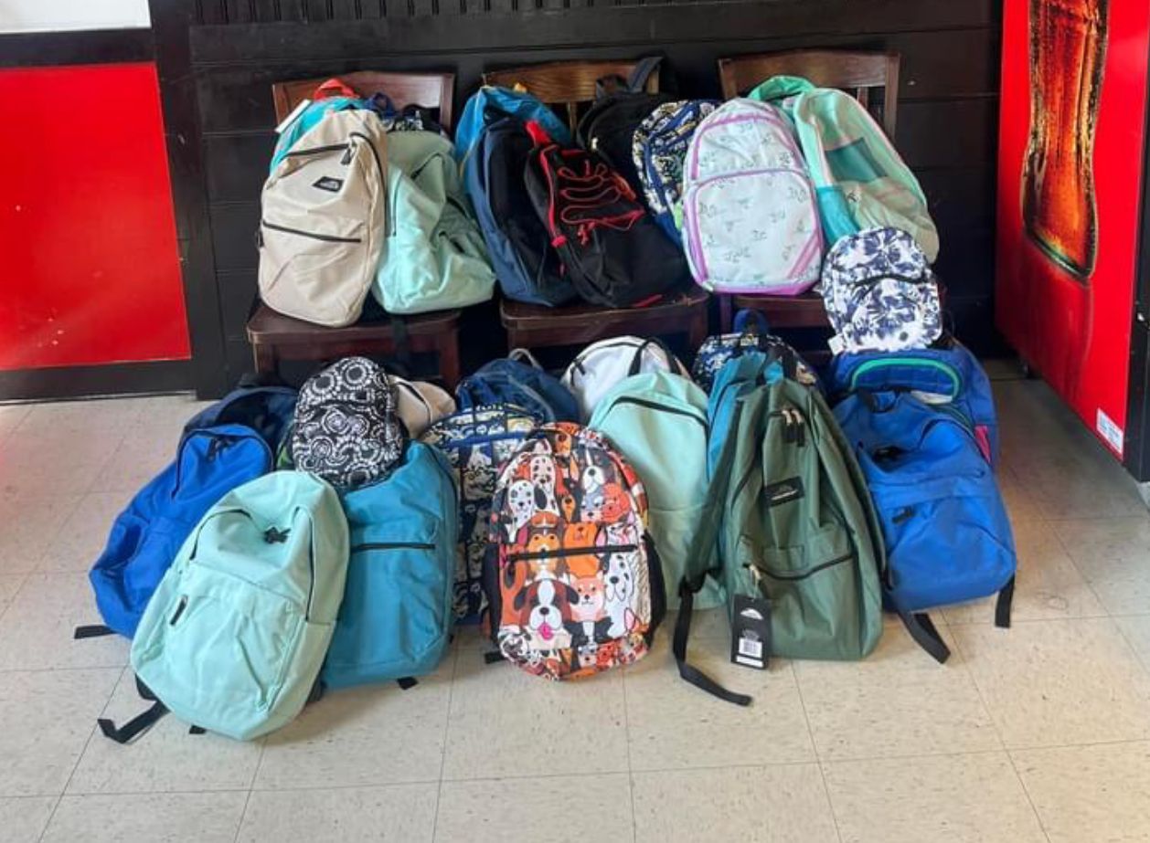 A bunch of backpacks are stacked on top of each other