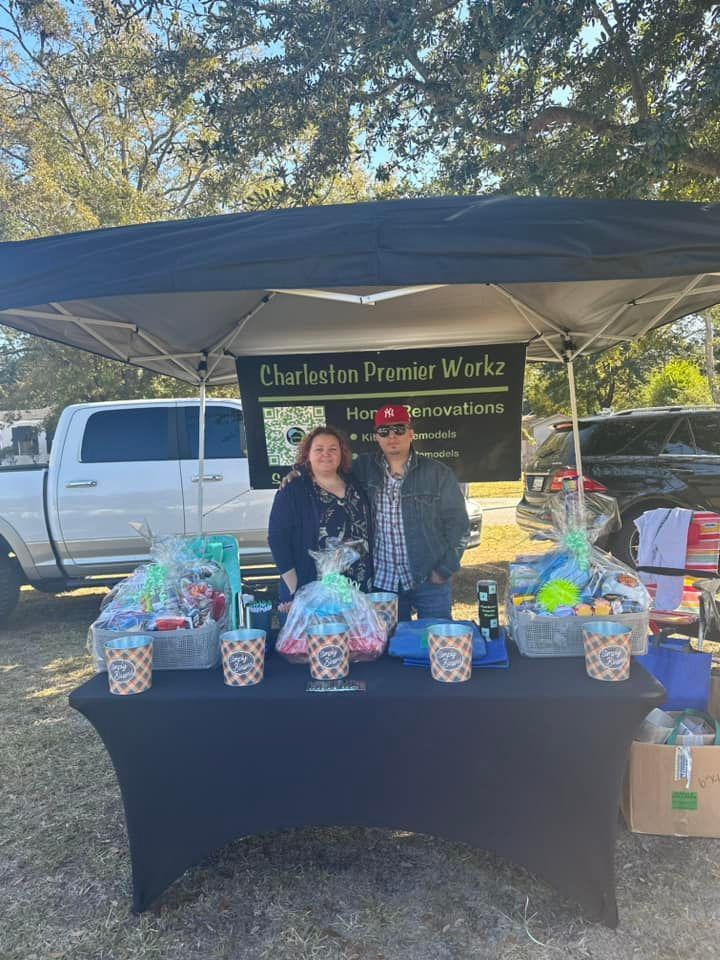A man and a woman are standing behind a table under a tent.