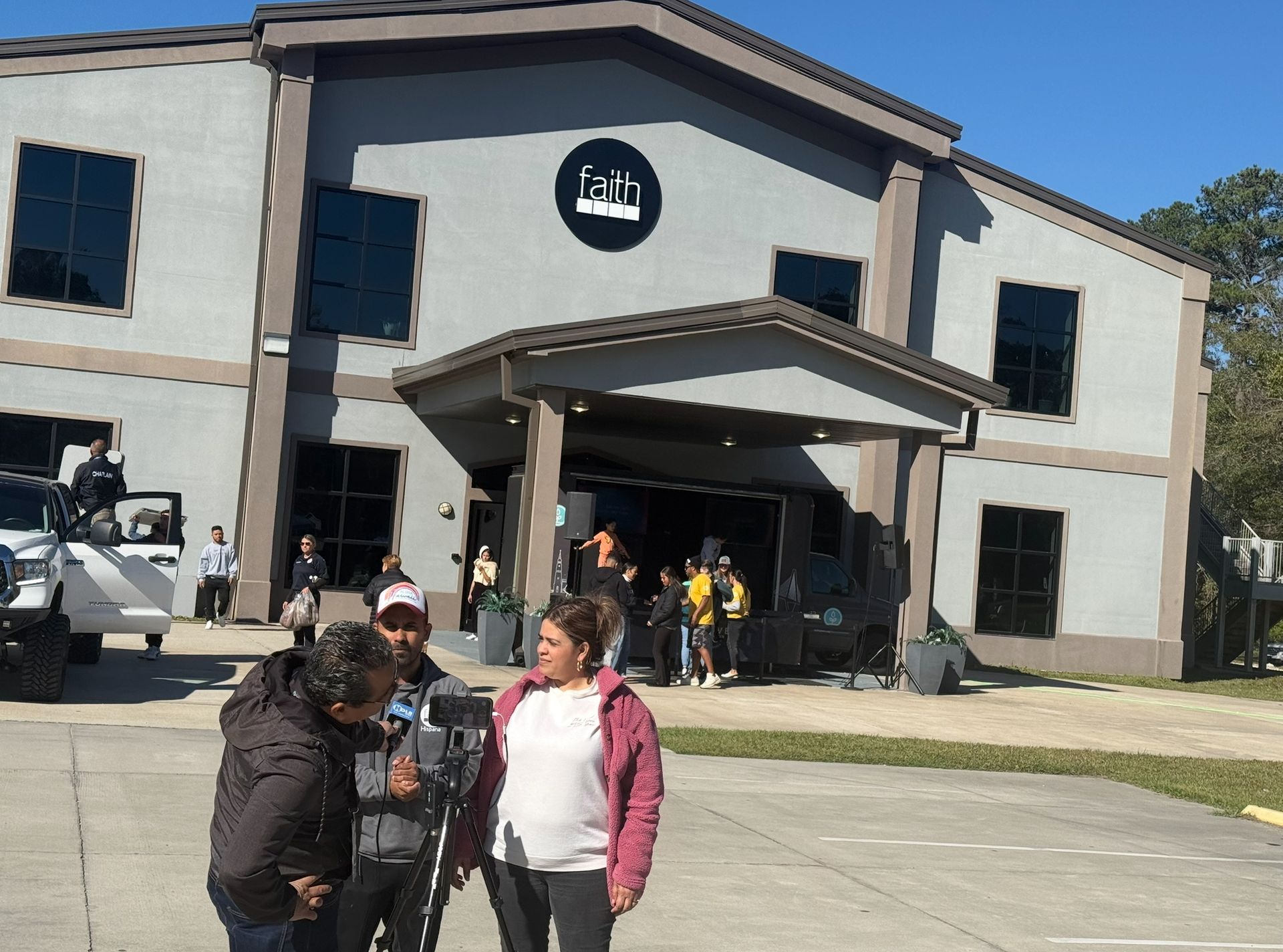 A group of people standing in front of a building that says ' fala ' on it