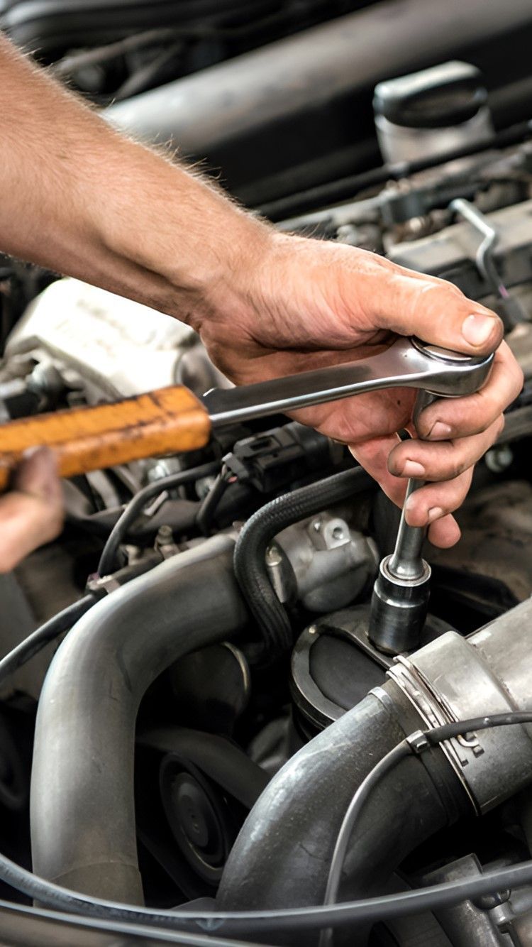 A Man Is Working On A Car Engine With A Wrench — Warrmech Mechanical In Tweed Heads South, NSW