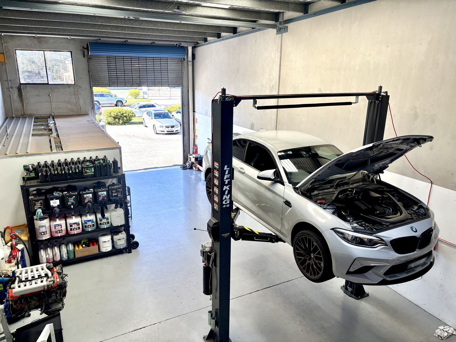 A Person Is Writing On A Clipboard In Front Of A Car Engine — Warrmech Mechanical In Tweed Heads South, NSW