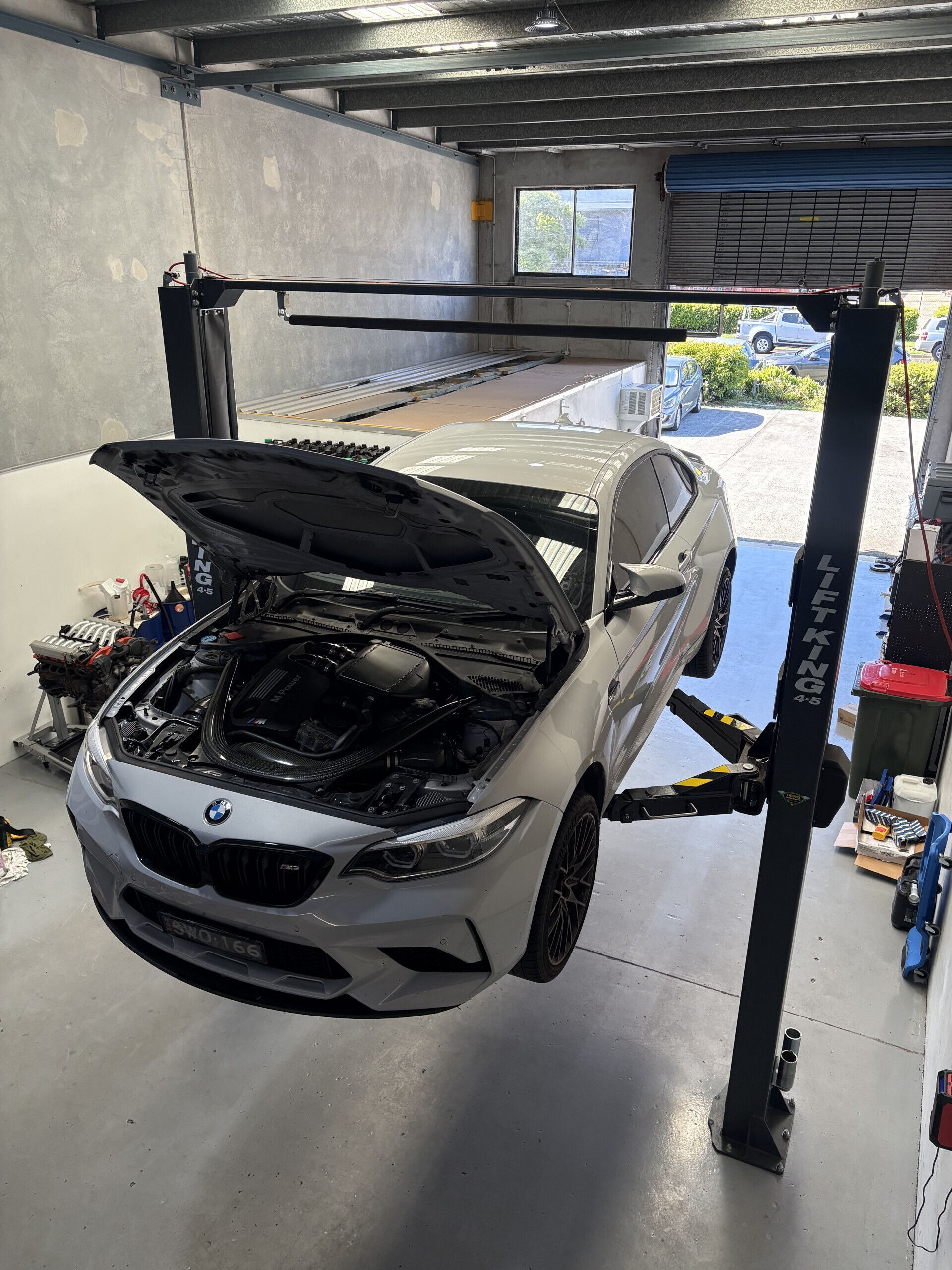 A Man Is Working On The Engine Of A Car With The Hood Open — Warrmech Mechanical In Tweed Heads South, NSW