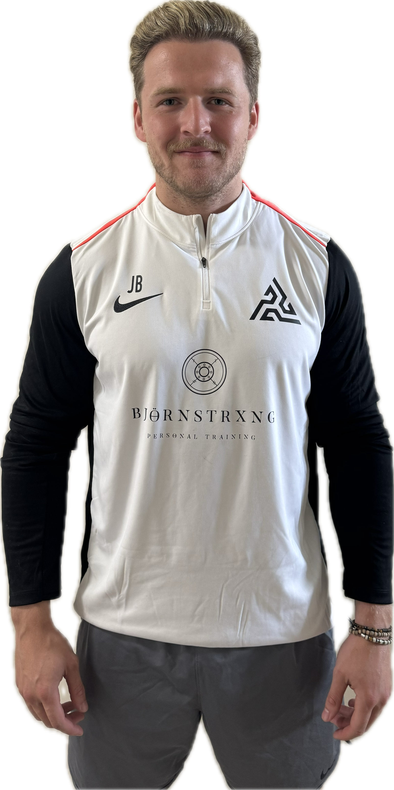 Man in white and black athletic shirt with a logo, standing and smiling.