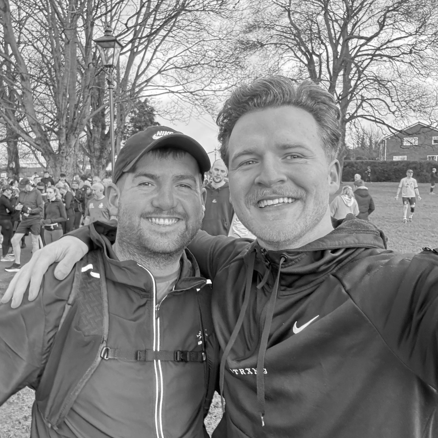 Woman doing tricep dips on a weight bench in a home gym, smiling, wearing Nike shirt and leggings.