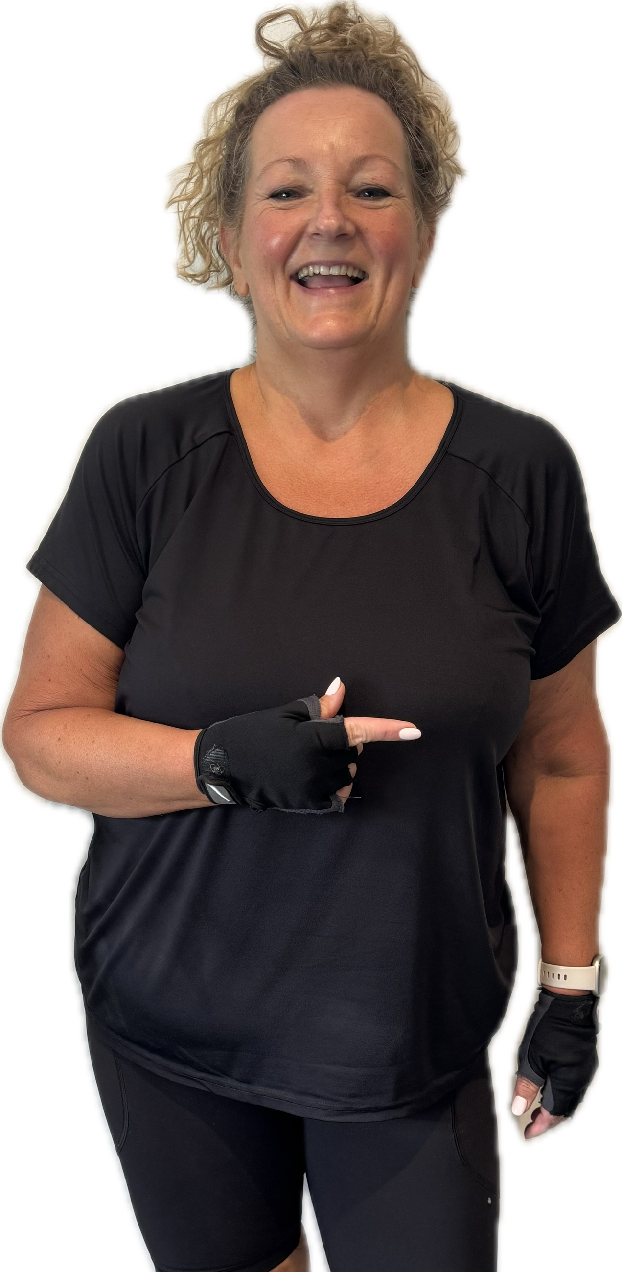 Woman in black workout clothes points to her side, smiling.