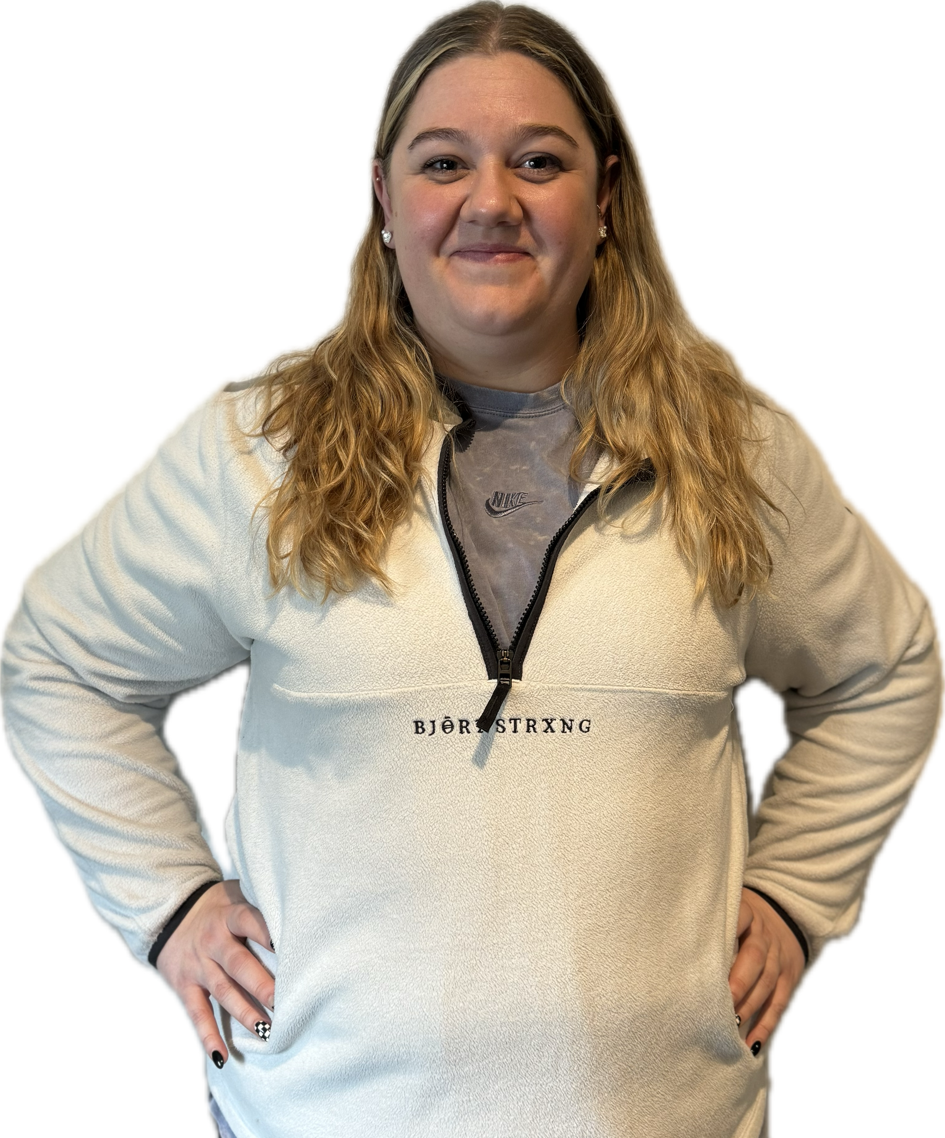 Woman with blonde hair, hands on hips, wearing a white sherpa pullover over a gray shirt.