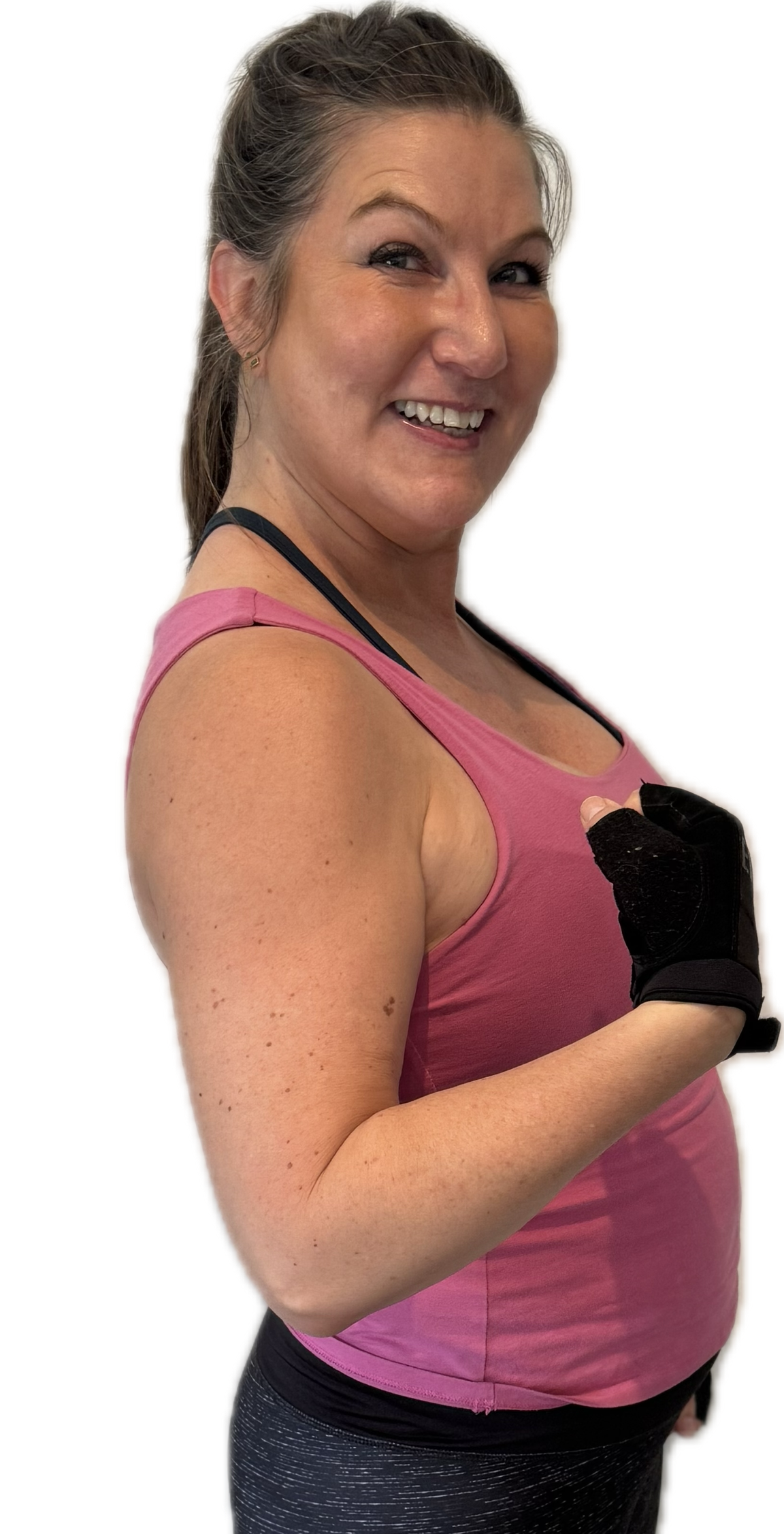Woman in pink tank top curls arm, wearing a black workout glove.