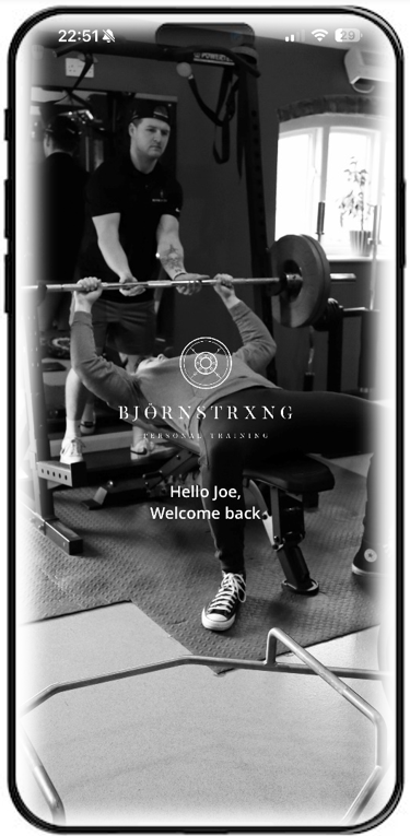 Person bench pressing with trainer spotting in a gym. Black and white photo.