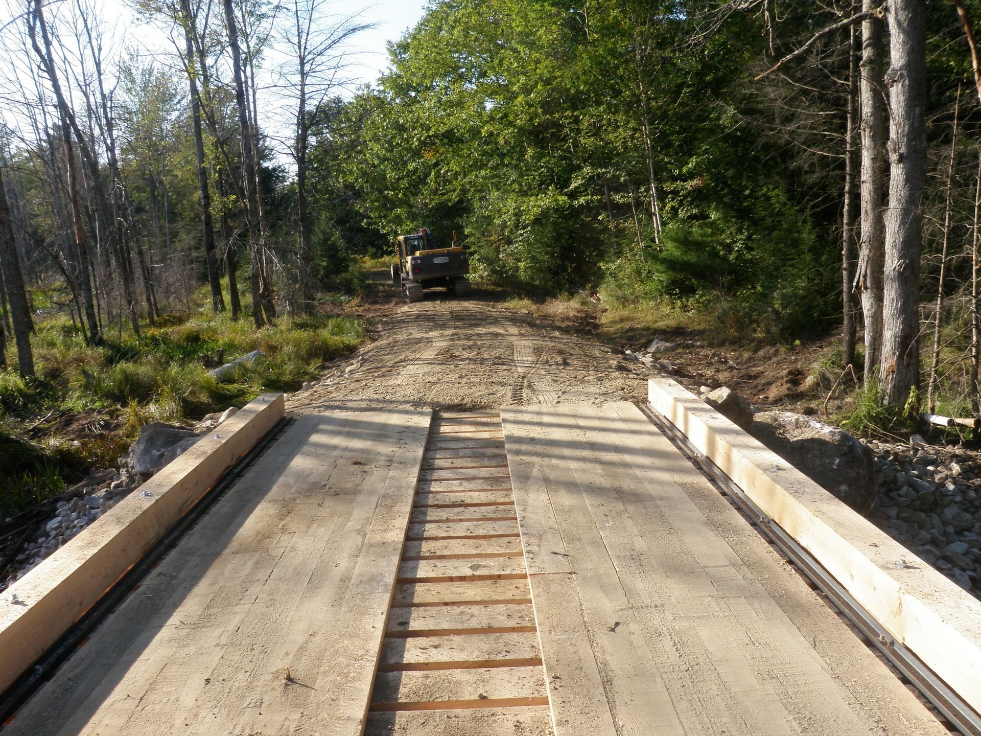 A white bathtub with beige tile walls and floor. A soap dish is mounted on the wall.