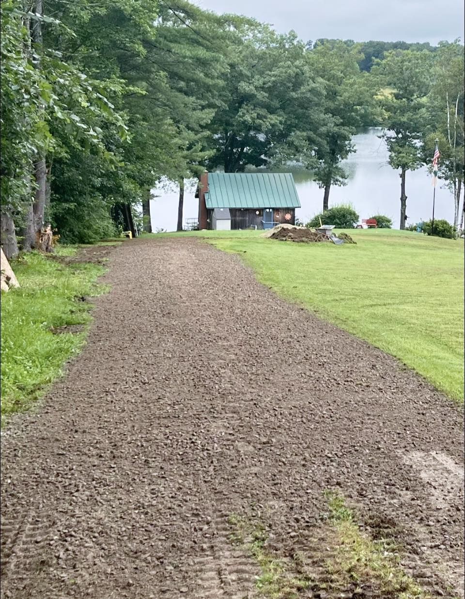 White bathtub with tiled walls in a bathroom, light brown floor, faucet on the side.